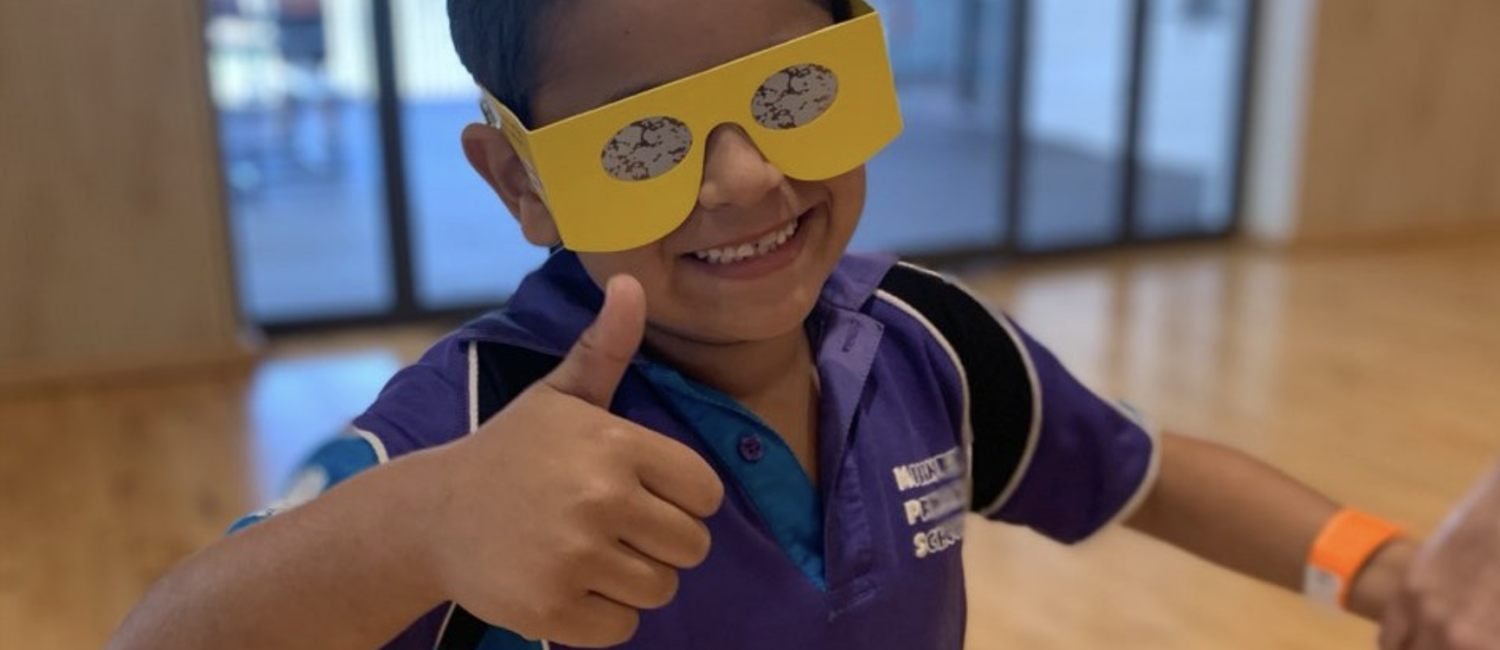 Young student wearing simulation glasses smiling at the camera giving a thumbs up